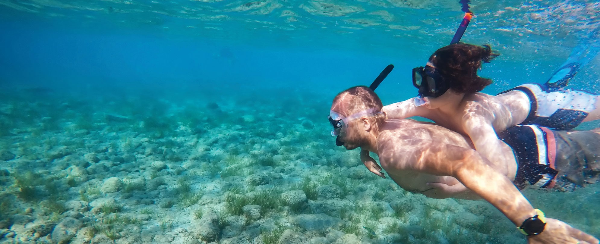 A man and a woman snorkeling on a trip booked with Club Wyndham Travel Services.